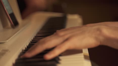 close up shot of the hands of a musician playing the piano on a keyboard