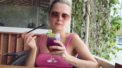 woman enjoying a purple drink outdoors