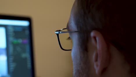 Close-up-video-editor-wearing-blue-light-blocking-glasses-whilst-working