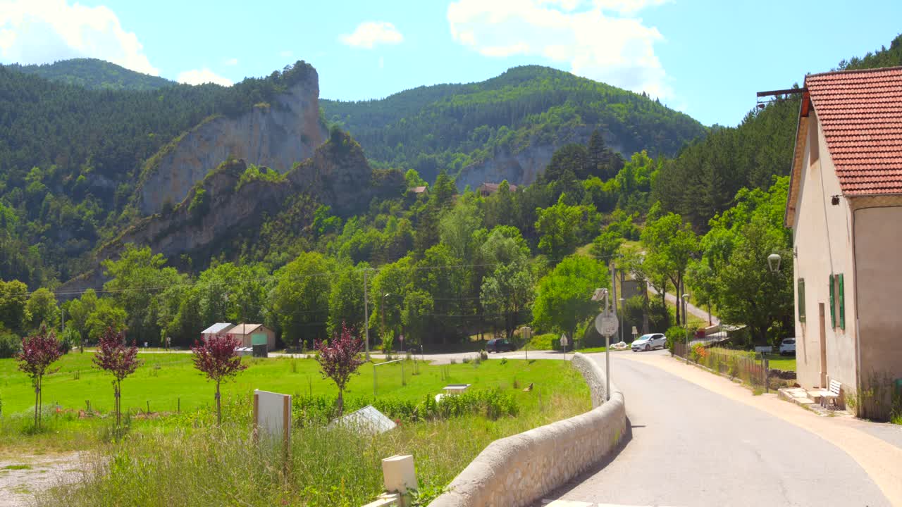 Quaint village of Glandage, France, surrounded by lush green mountains and clear skies