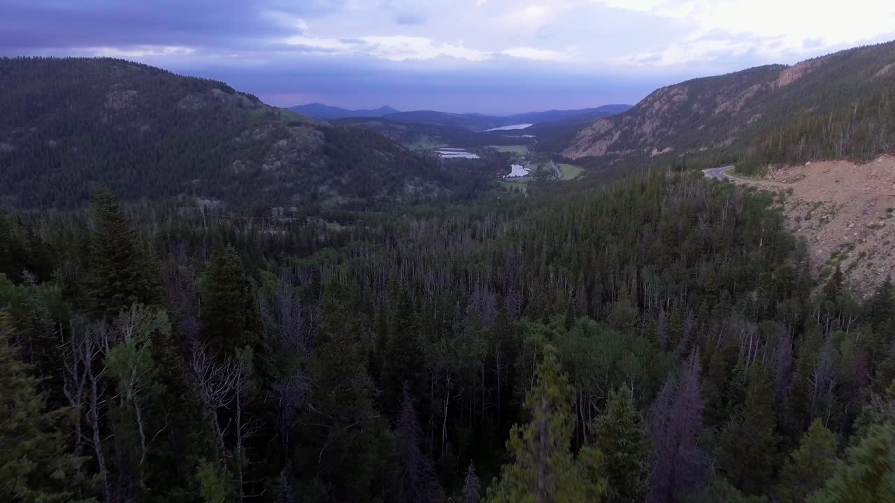 un avión volando a través de los árboles de la montaña abriéndose al valle de los pinos, volando sobre el hermoso paisaje de colorado, el mar verde de árboles en el avión de colorado