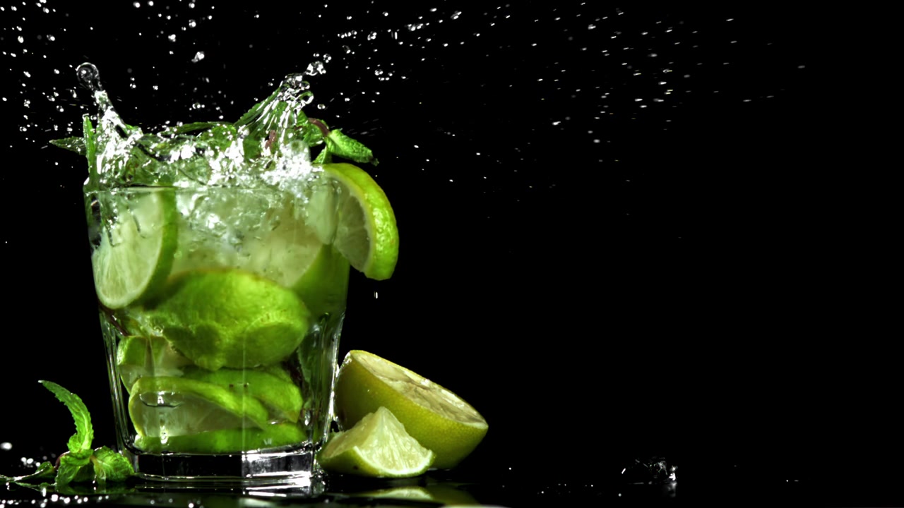 W zwolnionym tempie: kostki lodu wpadające z pluskiem do świeżego drinka Mojito