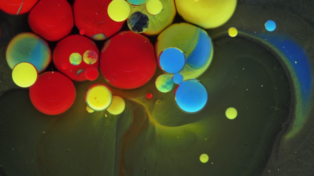 Colorful bubbles. Abstract red, yellow, blue, green mixture on a black background. Artistic color paint background.