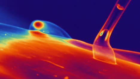 microscopic examination of thermal flow dynamics: observing the interaction between a probe and fluid surface with color-coded thermal imaging