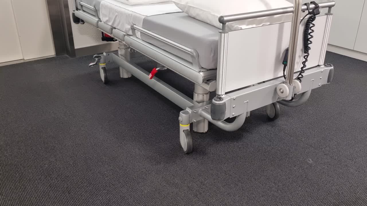 Hospitalsseng på hjul foran en moderne patientlift, frisklavet og klar til brug, der fremhæver Schweiz’ avancerede sundhedssystem og hospitalsmiljø