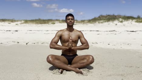 calm black man meditating on a beach with peace and tranquility