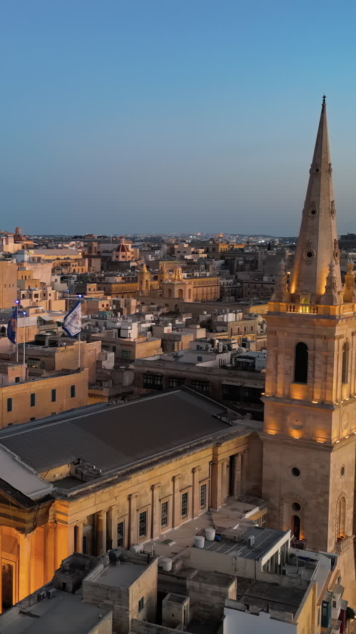 Aerial drone view of the walled city of Valletta, Malta, surrounded by the Mediterranean sea in the evening. Vertical vertical