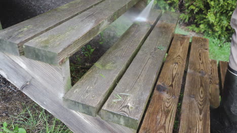 man pressure washing wooden stairs