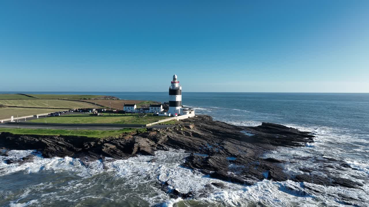 Faro di Hook Head, Wexford, Irlanda: ripresa aerea all'indietro di questa imponente struttura storica.