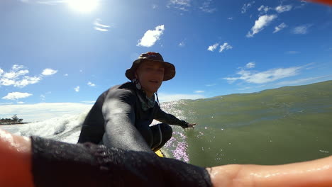 Close-up-shot-of-of-a-surfer-having-fun-while-surfing-along-the-sea-shore-in-Mui-Ne,-Vietnam-on-a-bright-sunny-day