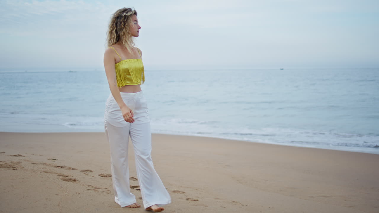 무관심한 소녀가 홀로 해변을 고 바다를 바라보고 있다. 은 모래를 고 있는 여자