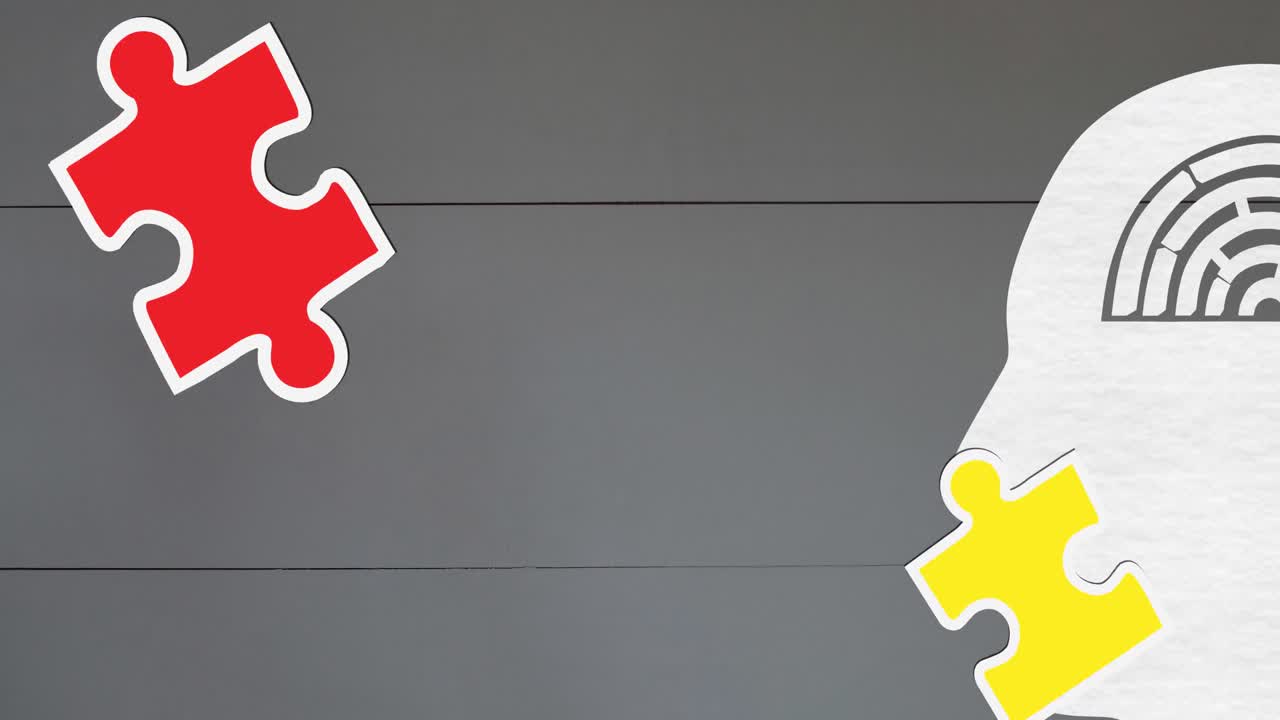 Animation of green, yellow and red puzzle pieces falling over model of human head on grey background
