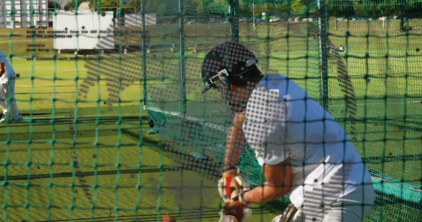 Cricket-slagmann øver på å svinge balltreet etter at kasteren løper og kaster ballen inn i treningsnettet