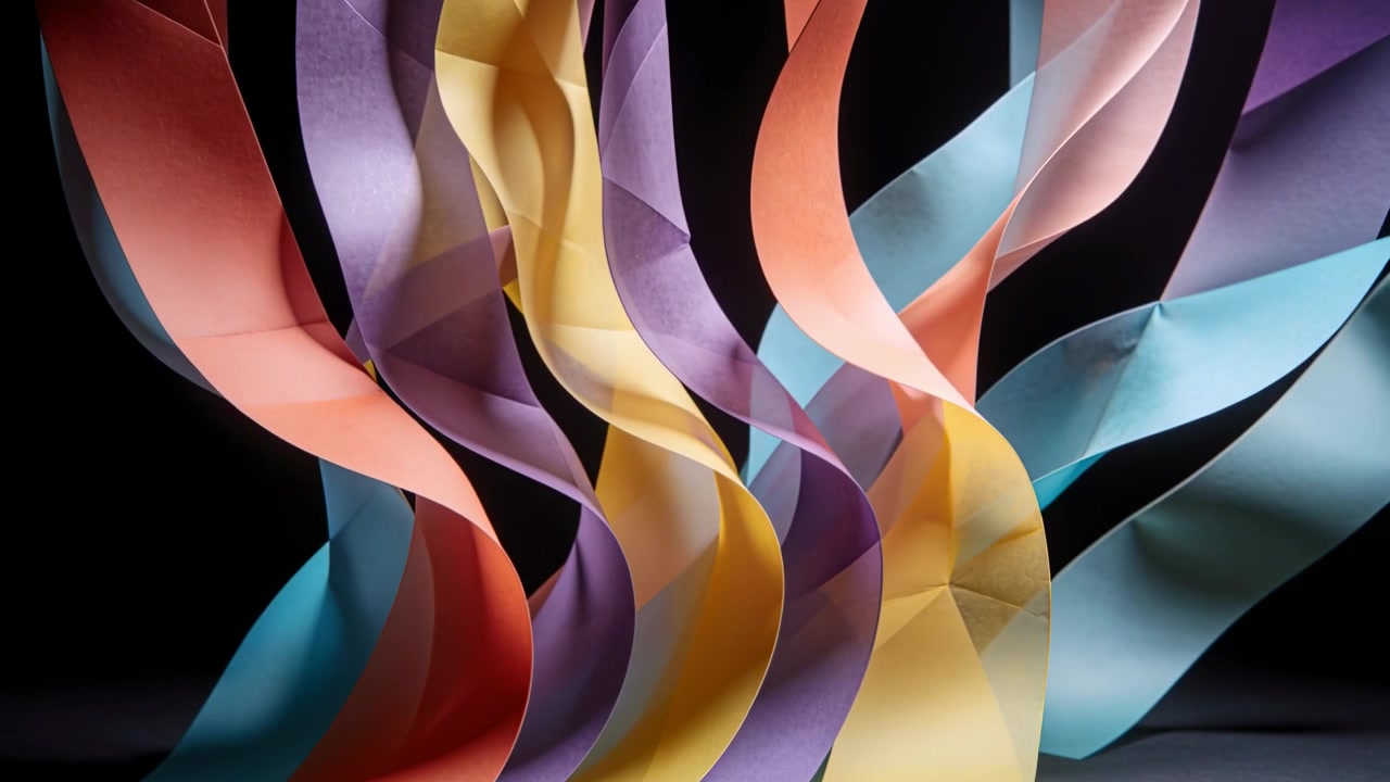 Shifting studio light causing curled paper ribbons opening peach purple, yellow, cyan on dark floor