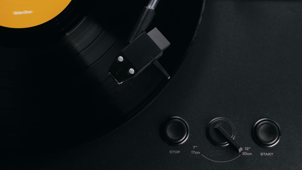 Retro Vinyl record player playing music, close-up macro shot of vintage LP disc old phonograph spinning. Retro music player.