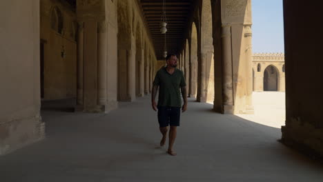 man exploring at ibn tulun mosque in cairo, egypt - pullback