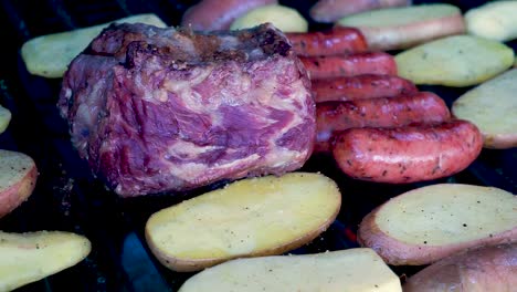 Primer-Plano-De-Carne-A-La-Parrilla-Con-Chorizos,-Tortillas-De-Queso,-Frijoles-Guatemaltecos-Y-Papas-Asadas-Ahumadas-Y-Preparación-Jugosa-Lista-Para-Comer-En-Familia-En-Un-Día-De-Temporada-De-Verano-[hd1920-X-1080]-Fps-29