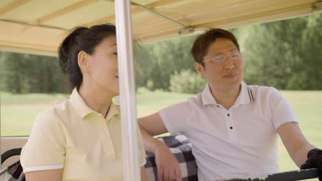 Marido-Y-Mujer-Hablando-Y-Riendo-En-Carrito-De-Golf