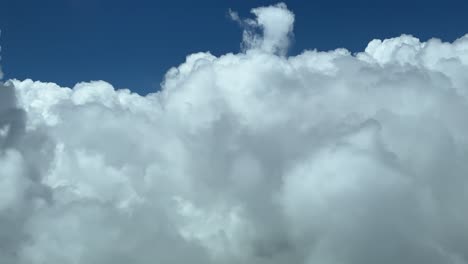 Volando-A-Través-De-Un-Cielo-Lleno-De-Cúmulos,-Grabado-Desde-Una-Cabina-De-Jet-Real-Mientras-Volaba-A-Nivel-De-Crucero-A-12000-M-De-Altura