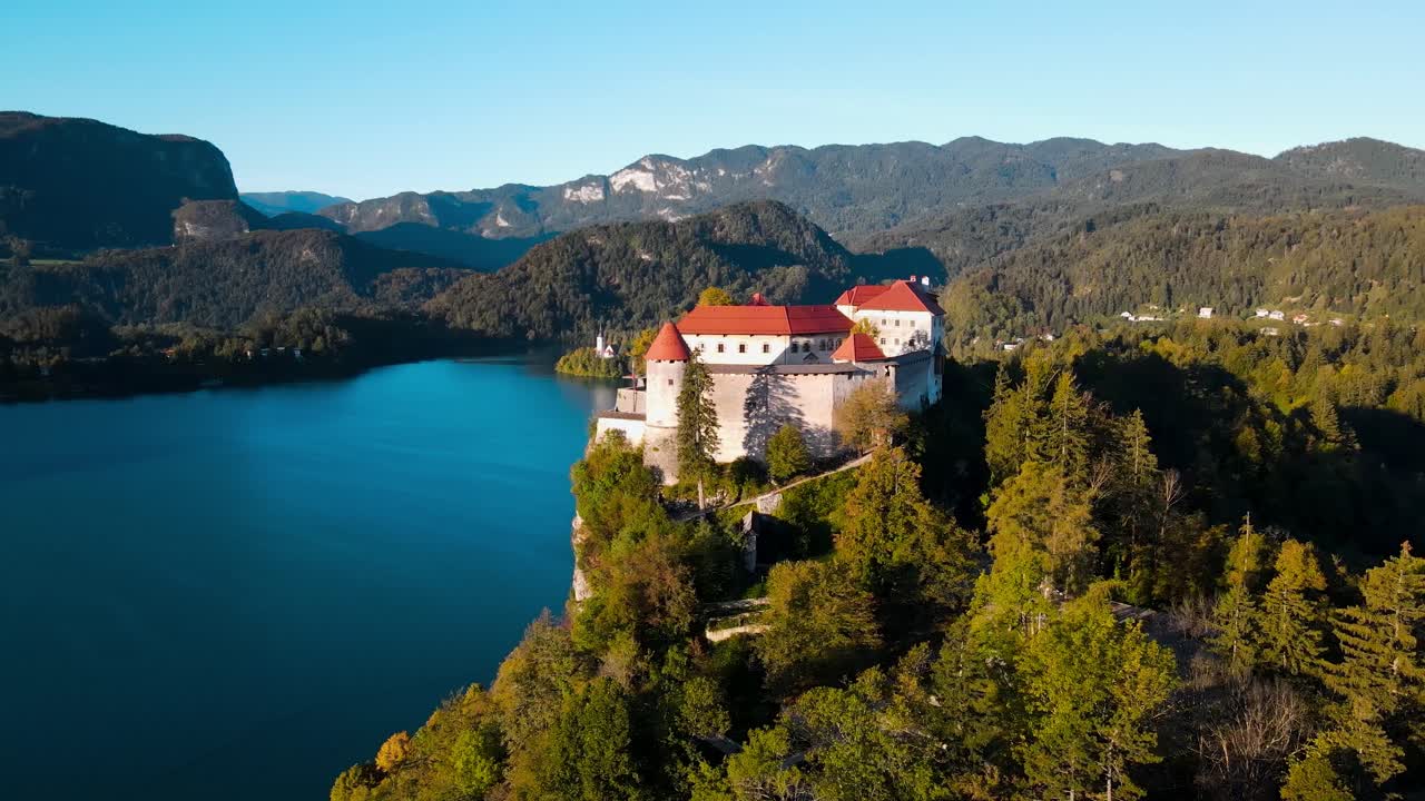 Aerea: il castello di Bled con vista sul lago di Bled all'alba con la foresta e il paesaggio a Bled, Slovenia, ripresa orbitale con drone