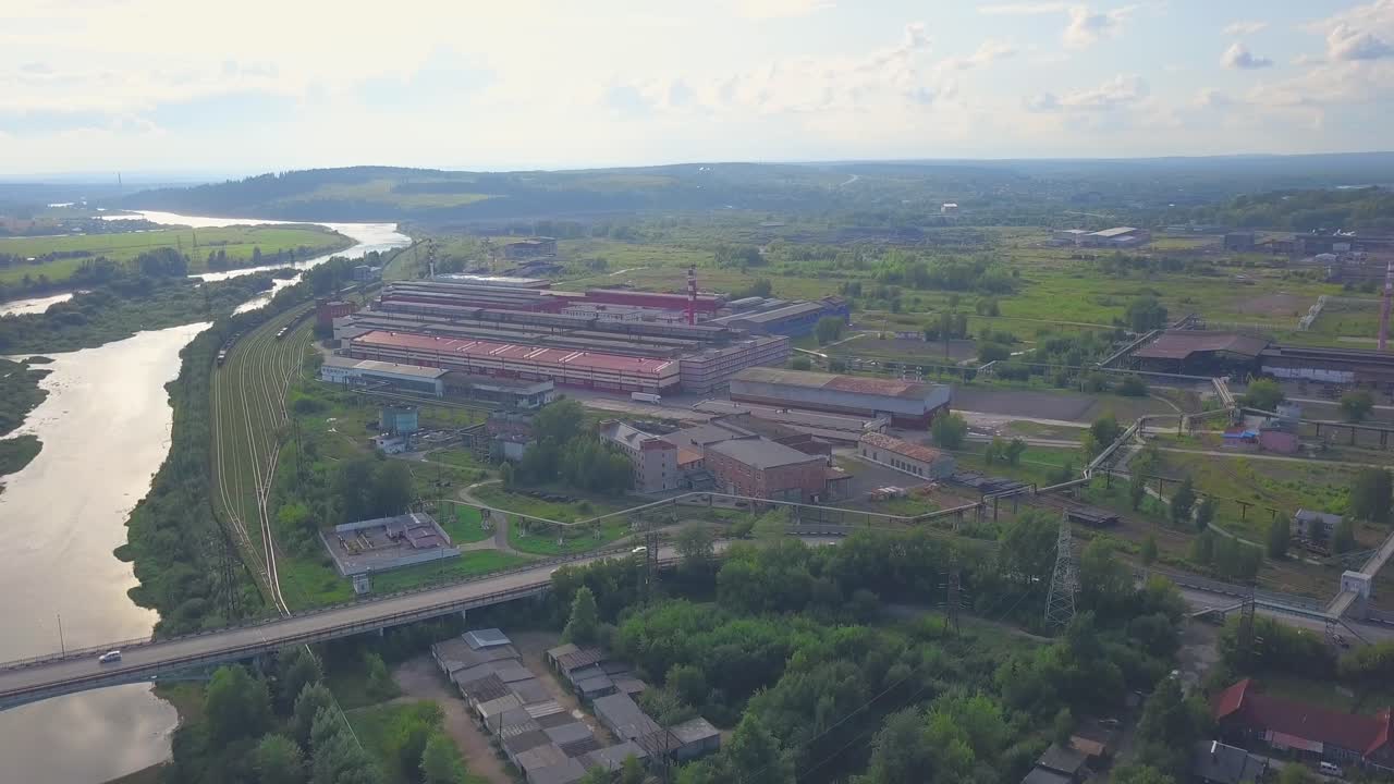 강 근처 에 있는 금속 공장 단지 의 공중 사진