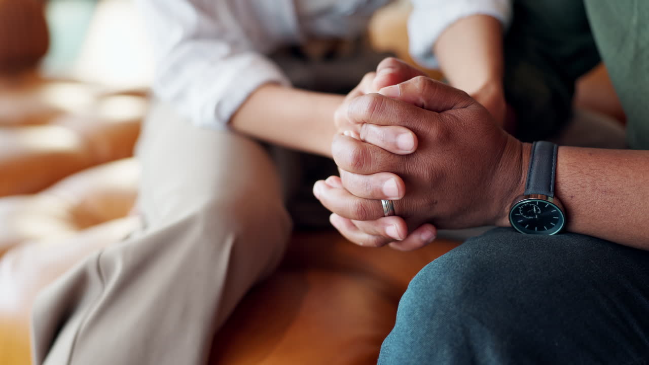 Supportive couple holding hands