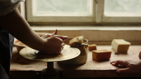 Unknown-woman-learning-pottery-handicraft-in-workshop.-Woman-making-pot