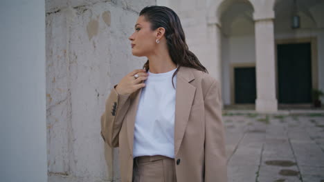 gorgeous model posing urban street leaning on concrete building wall close up.