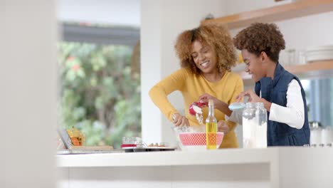 Glückliche-Afroamerikanische-Mutter-Und-Sohn-Backen-In-Der-Küche,-Zeitlupe