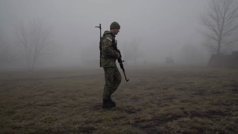soldier in camouflage uniform walking through fog