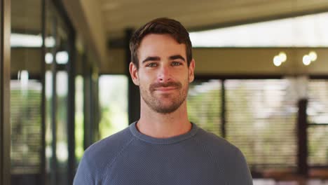 Portrait-of-happy-caucasian-man-in-living-room,-smiling-and-to-camera