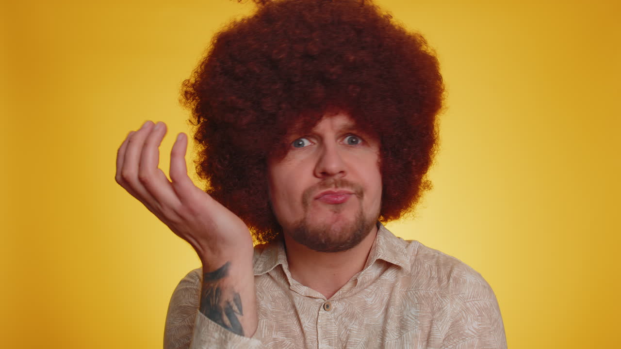 Man with afro wig looking confused