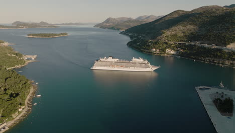 boat cruise ship in scenic harbor in dubrovnik, croatia in afternoon sun, aerial 5k drone