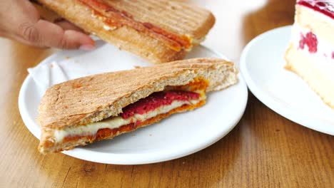 person eating a grilled sandwich in a cafe