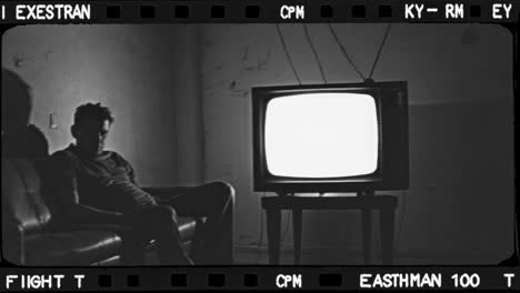 man sitting on couch in front of old tv