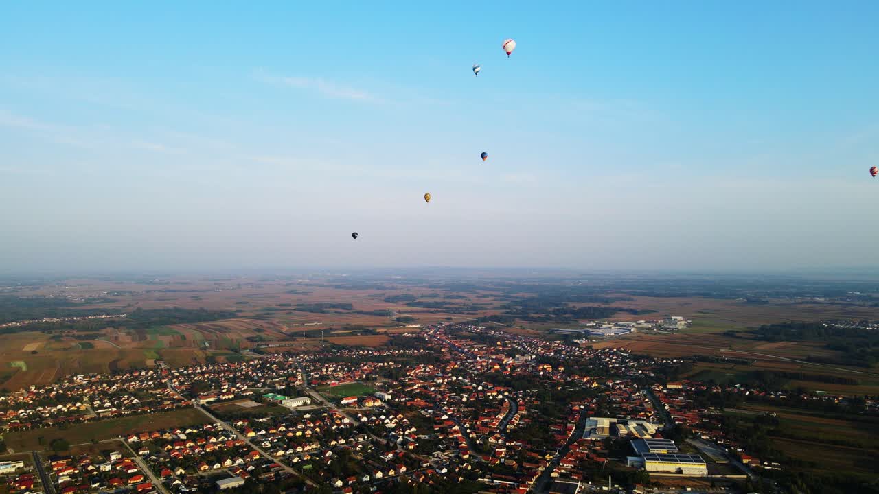 Stunning 4K aerial footage of a drone filming hot air balloons. Flying over farming fields and river. Filmed on a beautiful summer morning. Part of a hot air ballon festival in Prelog, Croatia.