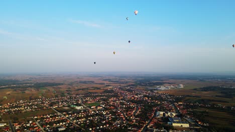 stunning 4k aerial footage of a drone filming hot air balloons. flying over farming fields and river. filmed on a beautiful summer morning. part of a hot air ballon festival in prelog, croatia.