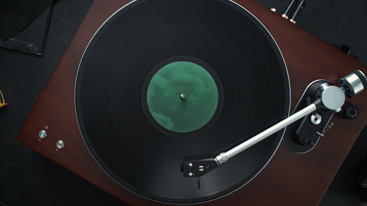 Vinyl Record Spinning in Slow Motion on a Turntable, with the Tonearm Lowered on the Record - Table Top View, Dolly out