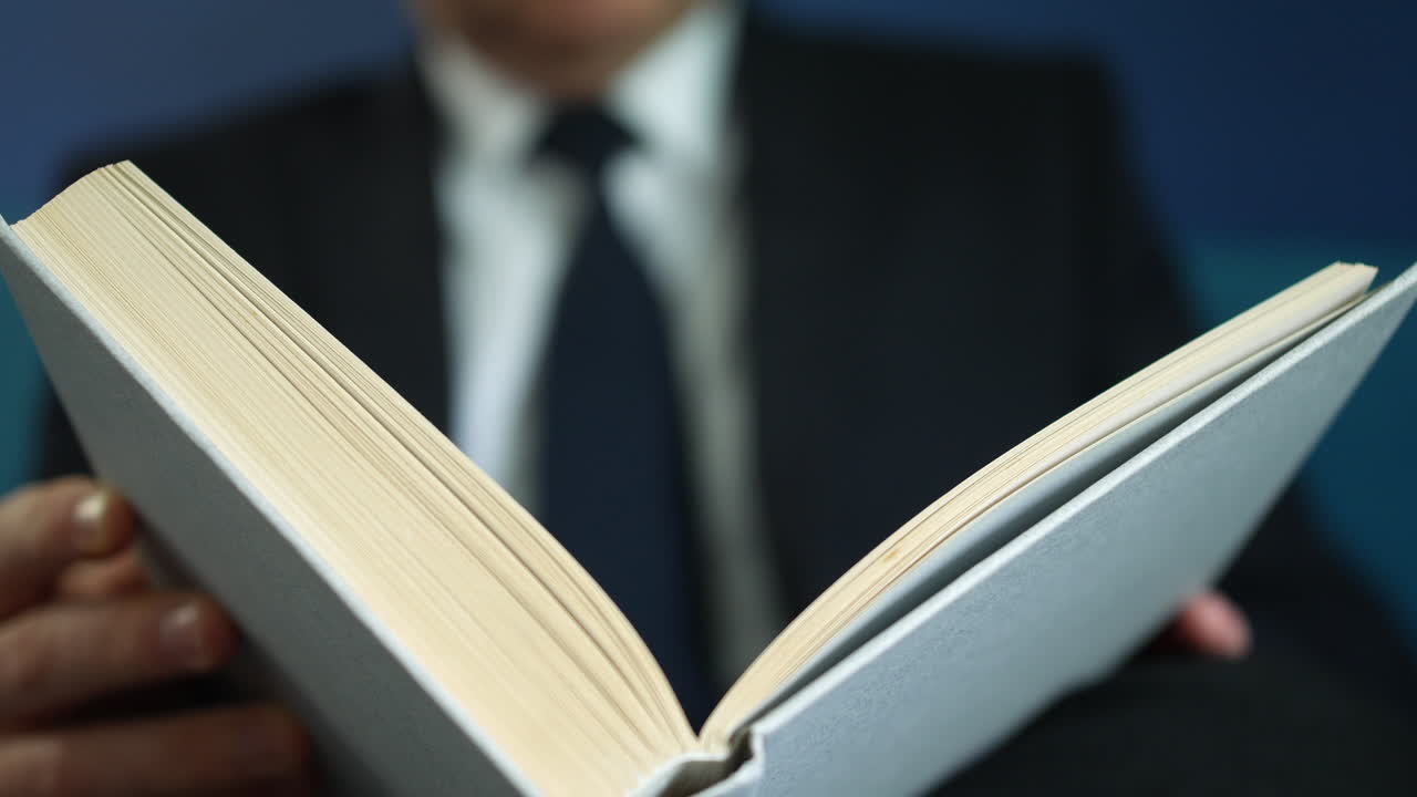 un hombre con traje de negocios leyendo un libro
