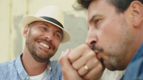 close-up de gay barbudo beijando a mão de seu amante