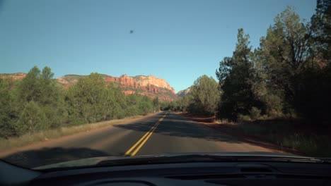 Beautiful-monumental-views-of-the-desert-rock-formation-in-front-of-the-car-while-driving-on-the-small-road-in-Arizona-near-Sedona-at-the-end-of-summer-2018