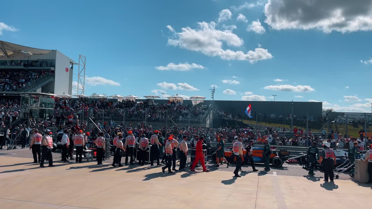 Austin, USA, 1 August 2022: Motorsport pit lane with mechanics and support staff on grid. Personnel and racing cars on the grid during a motor race event under a sunny sky at Circuit of the Americas