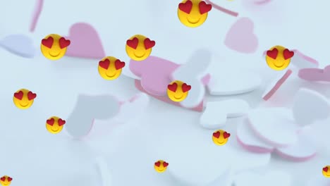 Multiple-heart-eyes-face-emojis-floating-over-multiple-hearts-falling-against-white-background