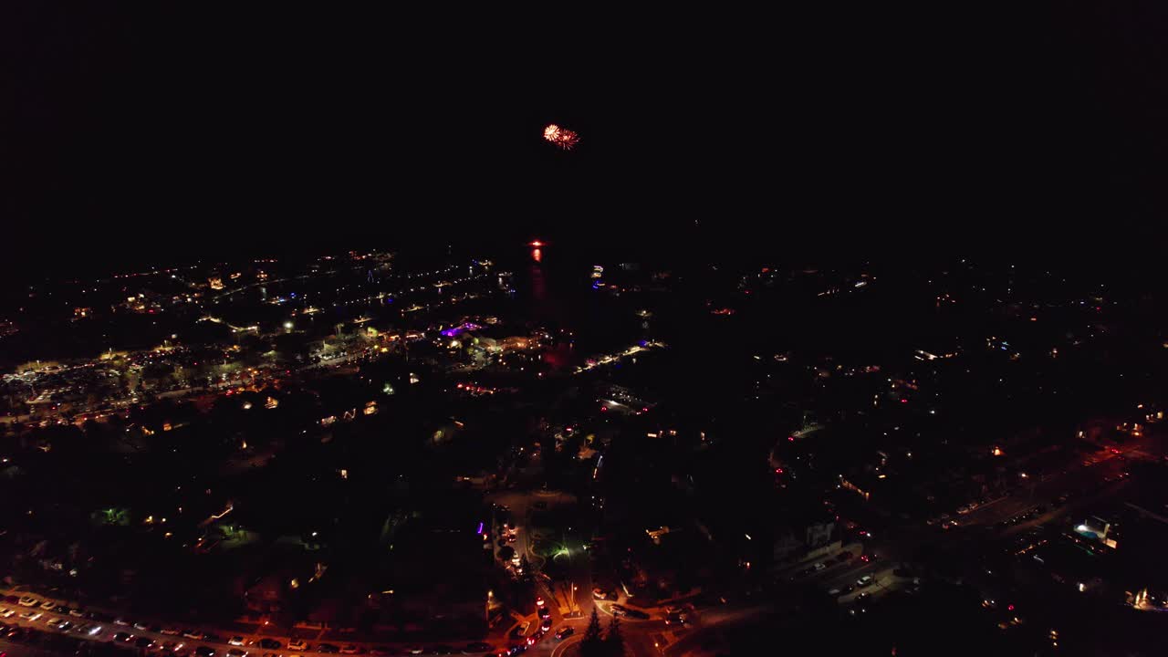 volando hacia y sobre una rotonda con tráfico aéreo nocturno de fuegos artificiales mindarie sobre el puerto deportivo y el océano