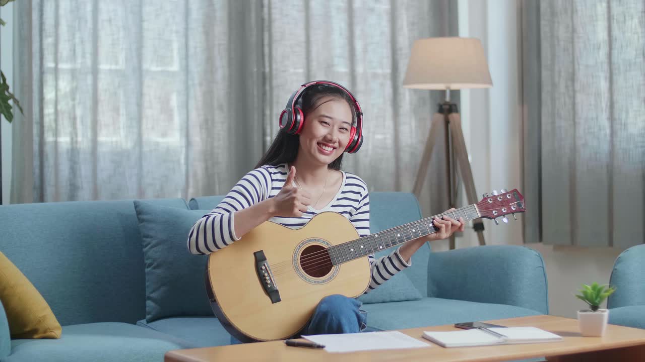 집에서 어쿠스틱 기타를 연주하는 여자
