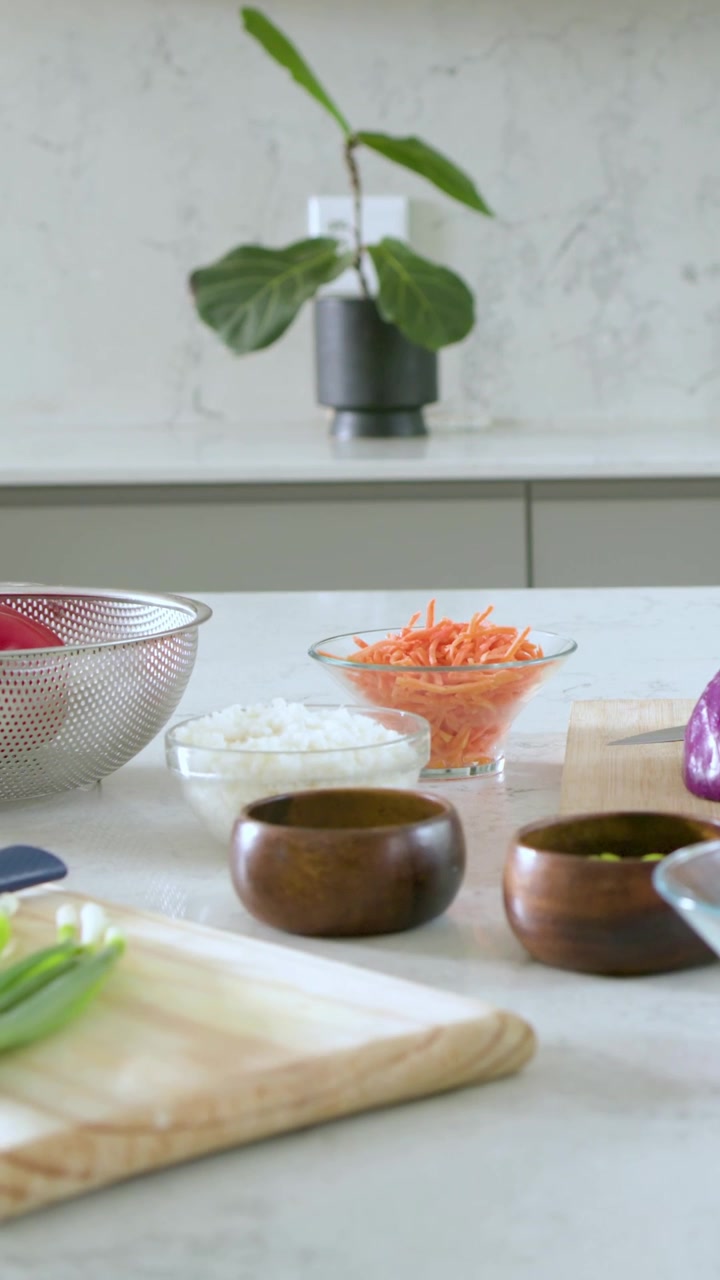 Vertical video: Camera framing kitchen showing carrots rice onions potted plant for meal prep