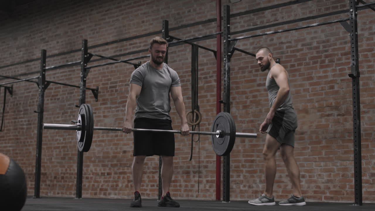 Trainer Watching Powerlifter Lifting Barbell