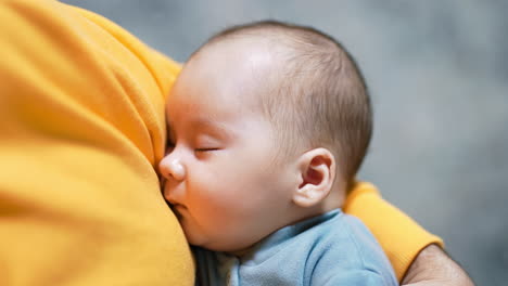 little toddler sleeps in the hands of a parent. baby with cute rosy cheeks sleeping sweetly. close up.