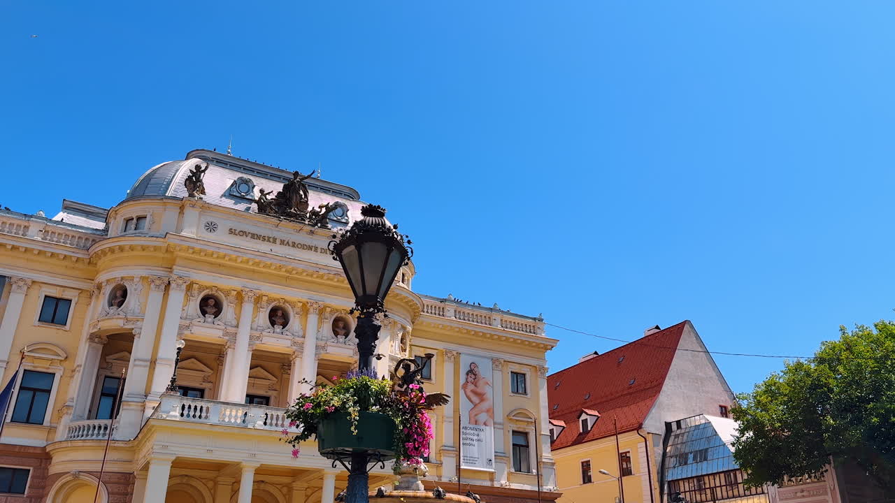 Gorgeous façade of the Slovak National Theatre with beautiful architectural elements. Fountain and street lantern in front of the entrance. Bratislava, Slovakia