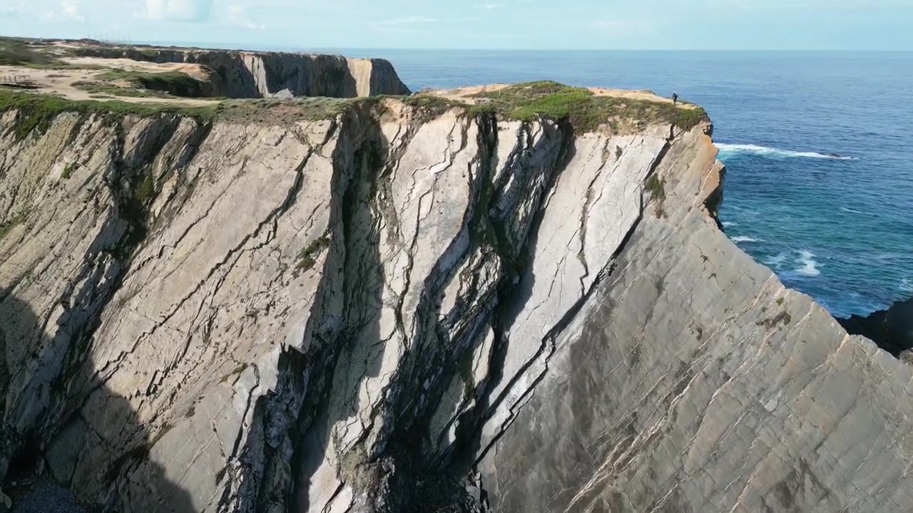 Riprese aeree con drone di Praia do Cavaleiro, Portogallo: aspre scogliere atlantiche, onde oceaniche e un paesaggio costiero drammatico sotto luce naturale. Ideale per progetti di viaggio e natura.